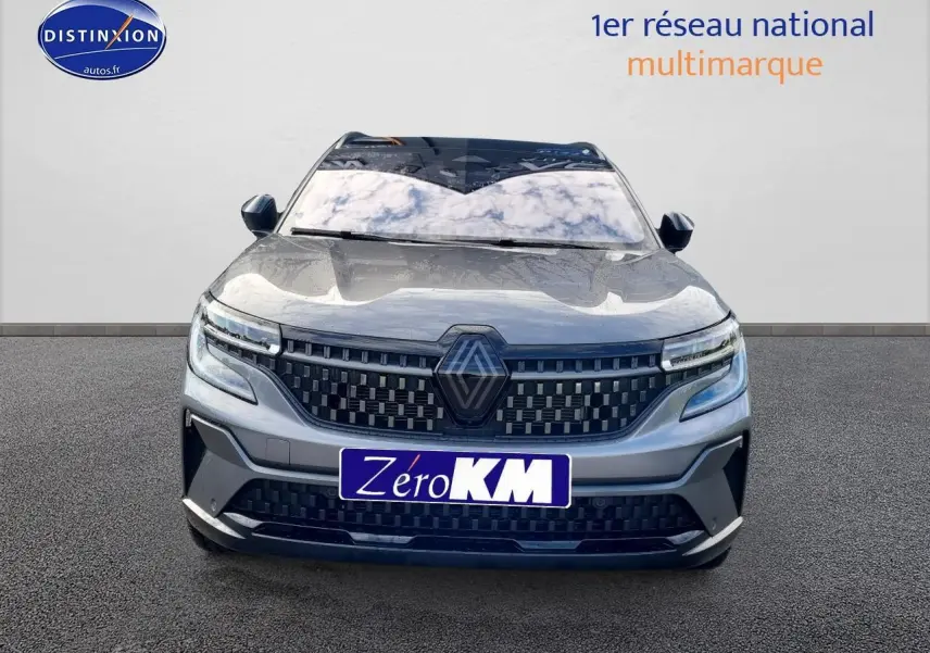 Vue frontale du Renault Espace VI gris schiste avec calandre damier et feux LED adaptatifs visibles.