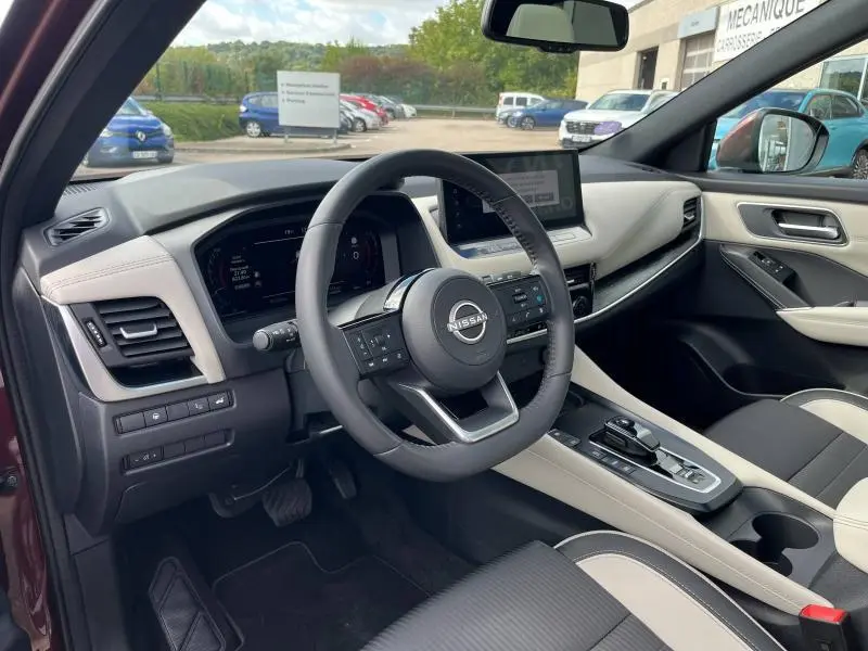 Intérieur du Nissan Qashqai e-POWER 2023 vu côté conducteur, volant cuir multifonction et tableau de bord digital.