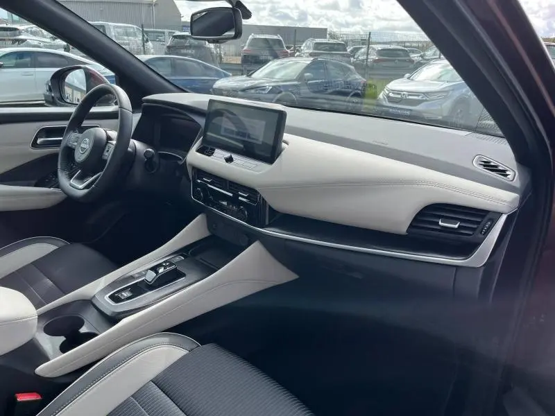 Intérieur avant droit du Nissan Qashqai e-POWER 2023 avec tableau de bord clair et écran tactile central visible.