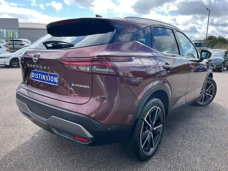 Vue 3/4 arrière droite d'un Nissan Qashqai e-POWER 2023 Rouge Passion avec jantes alliage 19 pouces et feux LED fins.