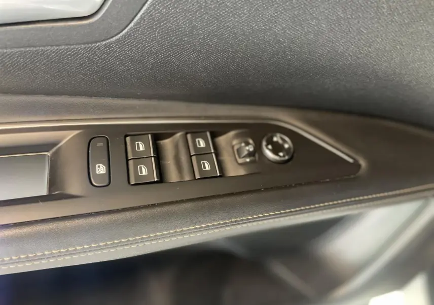 Détail des commandes de lève-vitres et rétroviseurs sur la porte côté gauche du Peugeot 3008 blanc nacré 2022.