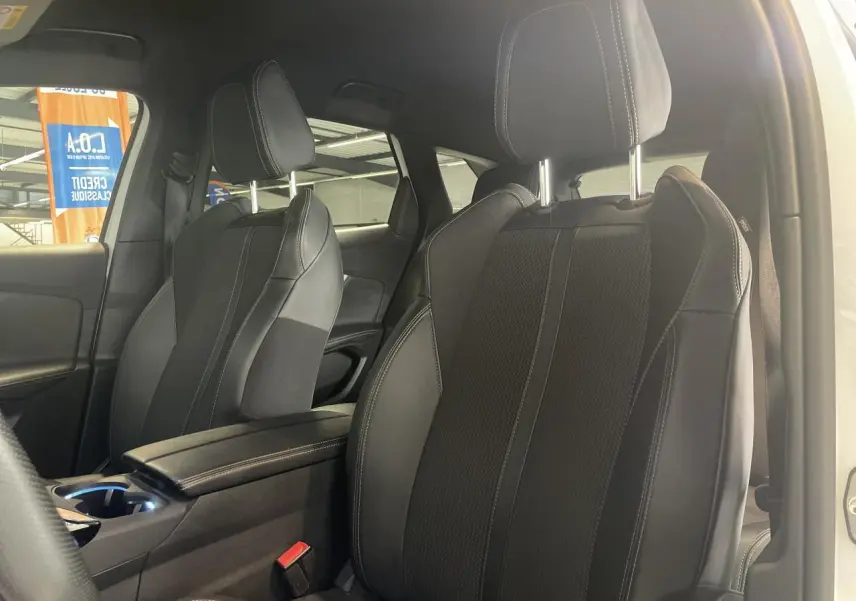Vue intérieure côté droit des sièges avant en cuir noir avec surpiqûres blanches du Peugeot 3008 GT blanc nacré 2022.