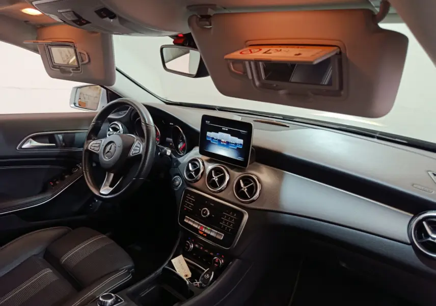Vue intérieure côté conducteur du Mercedes GLA 200 d 2018, tableau de bord noir avec écran central et volant cuir.