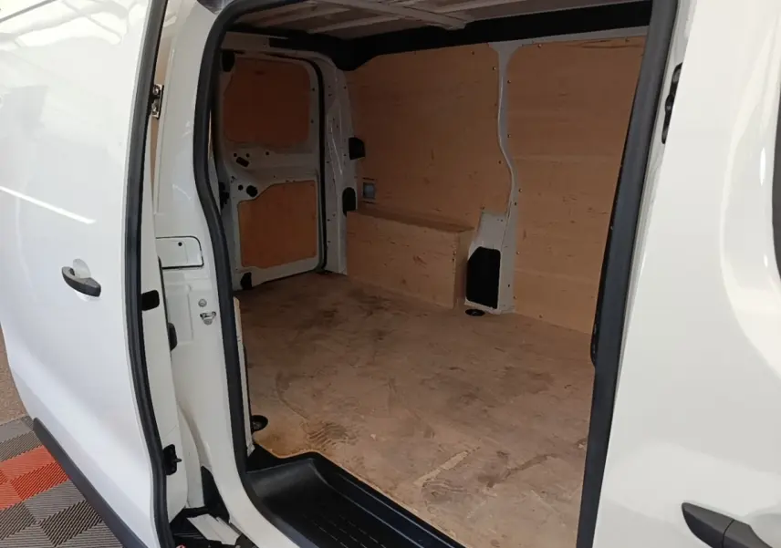 Vue intérieure côté droit du fourgon blanc Peugeot Expert avec aménagement bois brut dans l’espace de chargement.