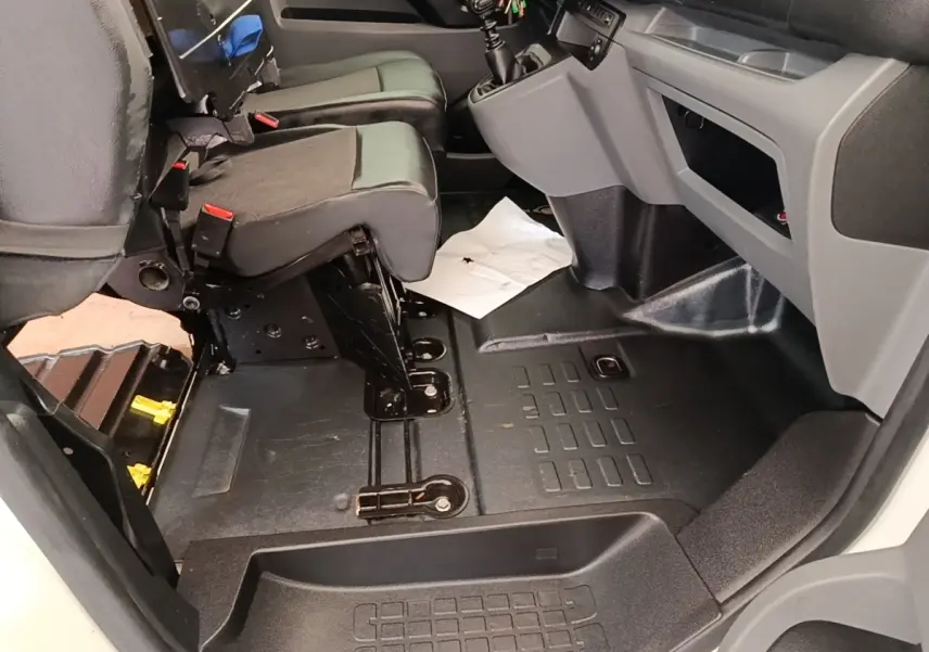 Vue intérieure côté passager avant du Peugeot Expert Fourgon 2020, montrant les sièges noirs et le plancher en caoutchouc.