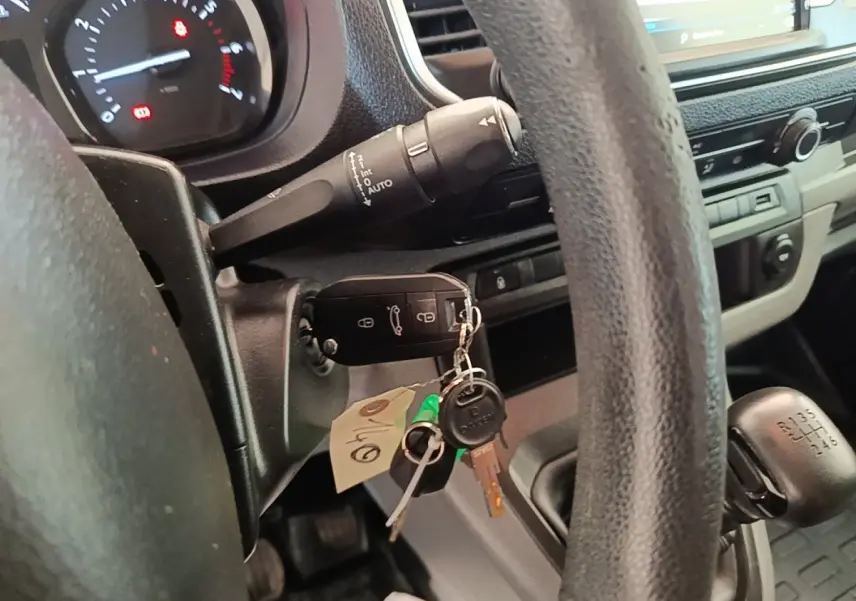 Vue intérieure côté conducteur du Peugeot Expert Fourgon blanc 2020, volant, clé de contact et levier de vitesse manuelle visibles.