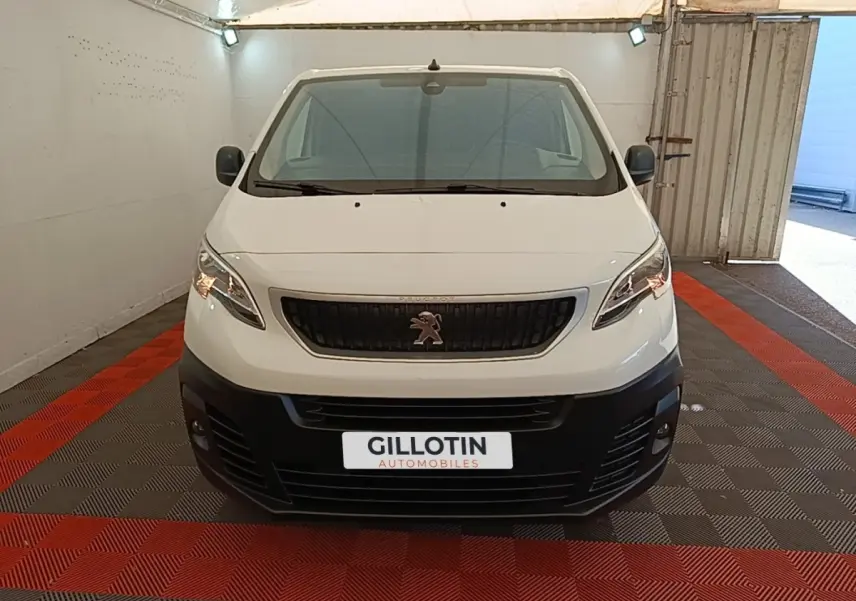 Vue avant d’un Peugeot Expert Fourgon blanc 2020 avec calandre noire et pare-chocs noir dans un garage.