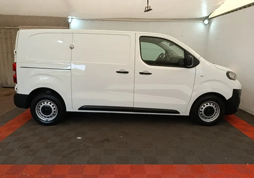 Vue de profil côté gauche d’un Peugeot Expert Fourgon blanc, avec portes latérales pleines et jantes acier noires.