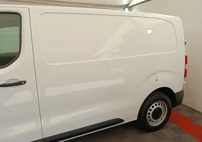 Vue latérale droite d'un Peugeot Expert Fourgon blanc, avec porte latérale pleine et jante acier noire.