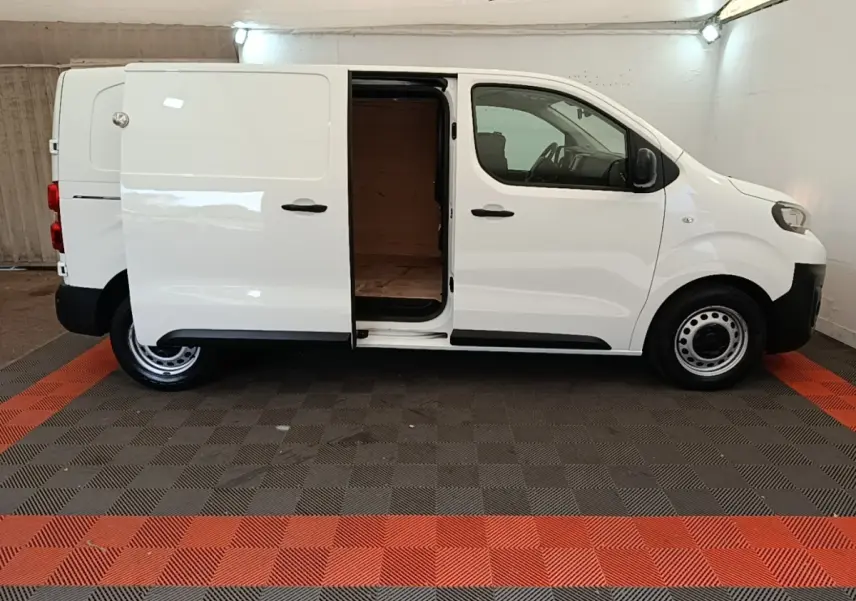Vue de profil côté droit du Peugeot Expert Fourgon blanc 2020 avec porte latérale coulissante ouverte montrant l'intérieur vide.