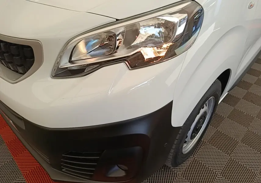 Gros plan sur l'avant droit blanc du Peugeot Expert Fourgon 2020, mettant en valeur le phare et le pare-chocs noir.