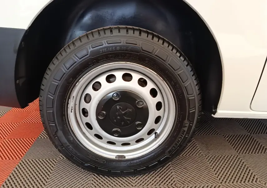 Gros plan sur la roue avant droite en jante acier du Peugeot Expert Fourgon blanc, avec pneu Michelin visible.