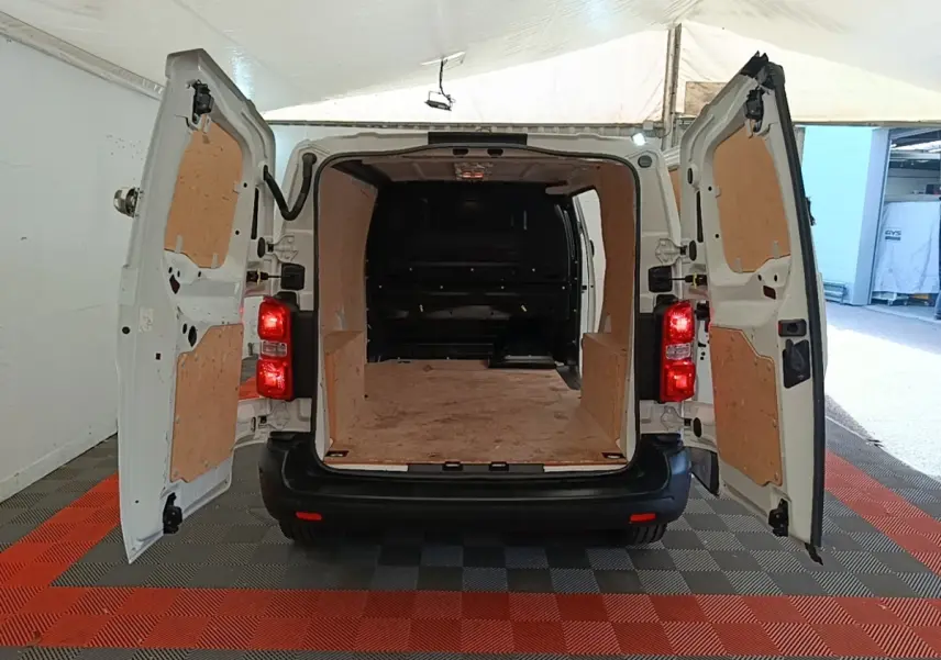 Vue arrière du Peugeot Expert Fourgon blanc 2020 avec portes ouvertes dévoilant l'espace de chargement en bois.