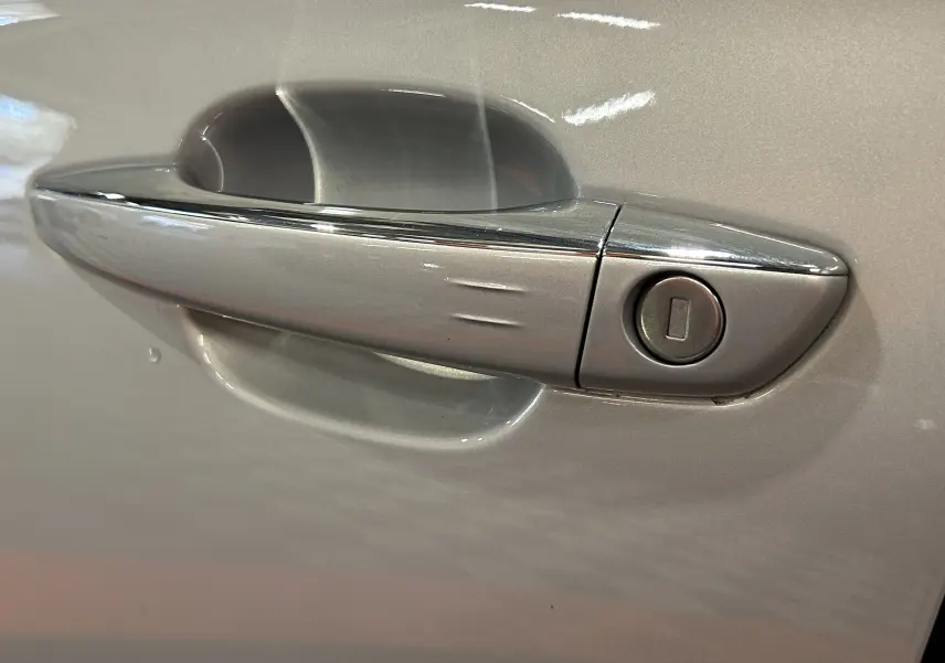 Poignée de porte chromée sur la portière côté gauche d'un DS7 2024 couleur Chrystal pearl.