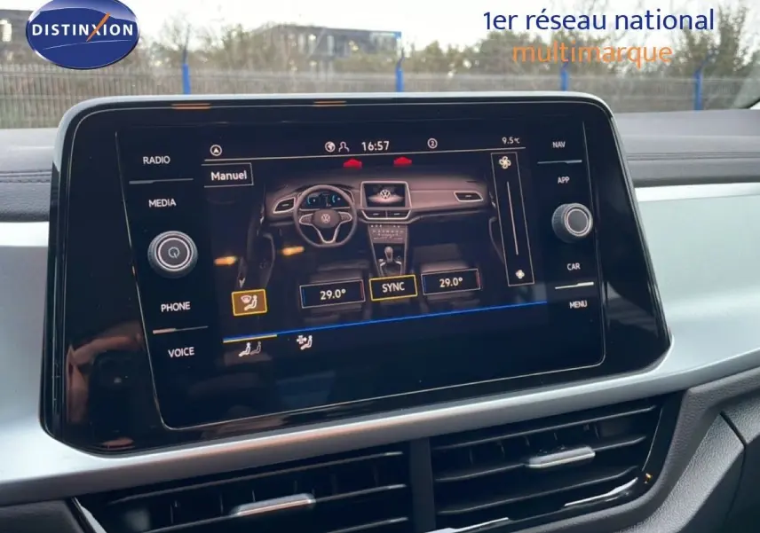Vue rapprochée de l'écran tactile central du Volkswagen T-Roc noir Grenadilla, affichant les réglages de climatisation et de navigation.
