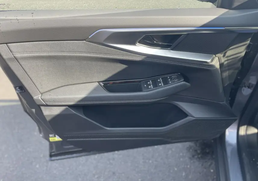 Vue côté gauche de la porte avant gris foncé du Renault Rafale 2025 avec commandes électriques et surpiqûres argentées.