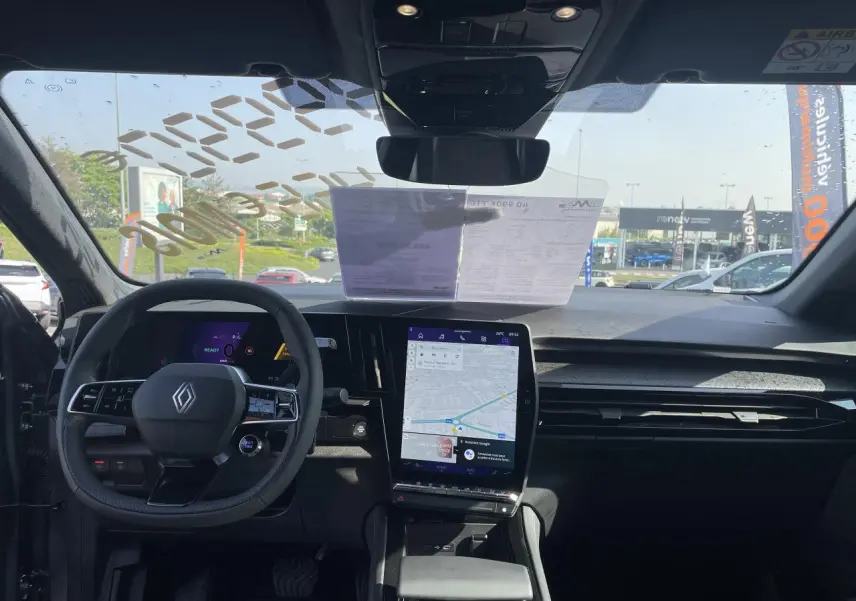 Vue intérieure avant du Renault Rafale 2025, tableau de bord noir avec écran tactile vertical et volant multifonction.