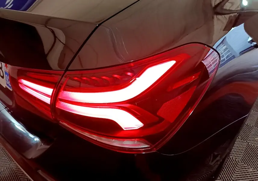 Gros plan sur le feu arrière droit allumé d'une Mercedes Classe A Berline A 200 d Progressive Line noire.