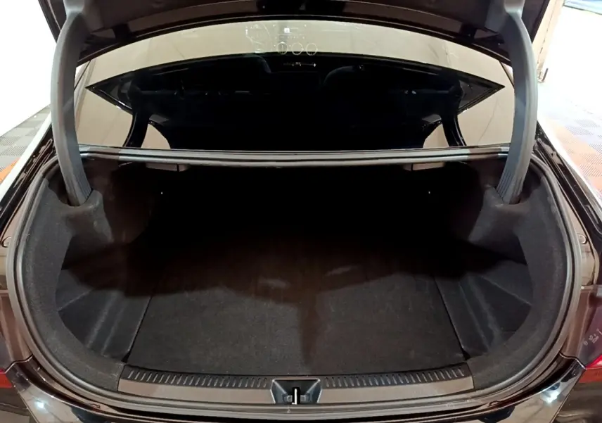 Coffre ouvert vu de l'arrière d'une Mercedes Classe A Berline noire, espace de rangement vide et propre.