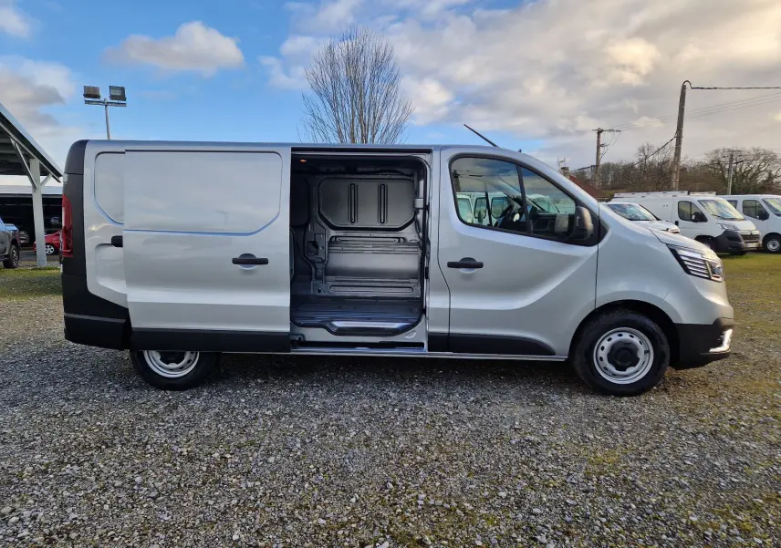 Vue latérale droite du Renault Trafic Fourgon gris Highland 2025 avec porte coulissante ouverte dévoilant l’espace de chargement.