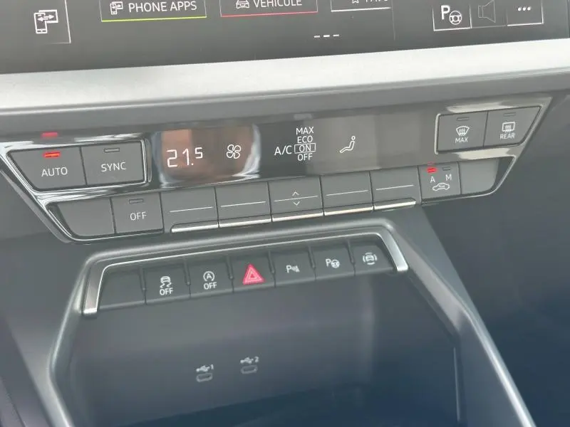 Détail du tableau de bord de l’Audi A3 Sportback 2024, montrant les commandes de climatisation et d’assistance au stationnement.