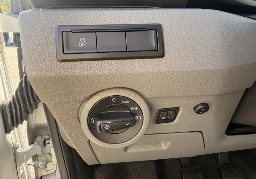 Gros plan sur le panneau de commande des phares gris clair du Volkswagen Transporter 2.0 TDi 110 L2H1 Business 2022.
