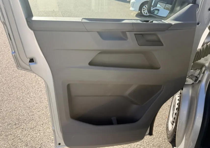 Vue rapprochée de la porte arrière droite grise claire du Volkswagen Transporter 2.0 TDi avec haut-parleur intégré.