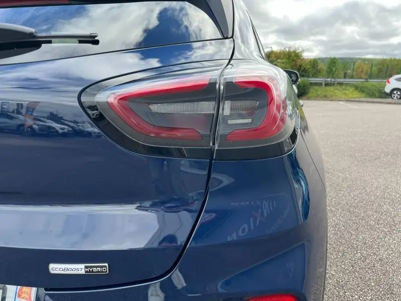 Gros plan sur le feu arrière droit d'un Ford Puma bleu Abysse 2023 avec badge EcoBoost Hybrid visible