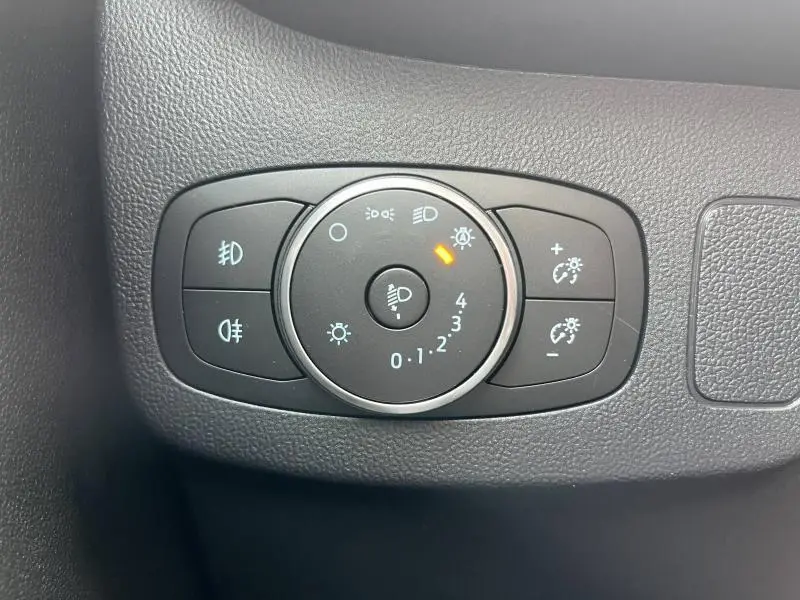 Gros plan sur la commande d'éclairage intérieure noire du Ford Puma 2023 avec réglage des phares et feux antibrouillard.