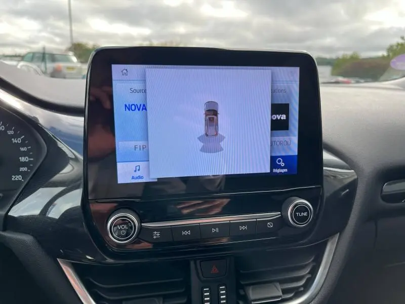 Écran tactile central du Ford Puma 2023 affichant la vue 360° du véhicule en stationnement, intérieur noir.