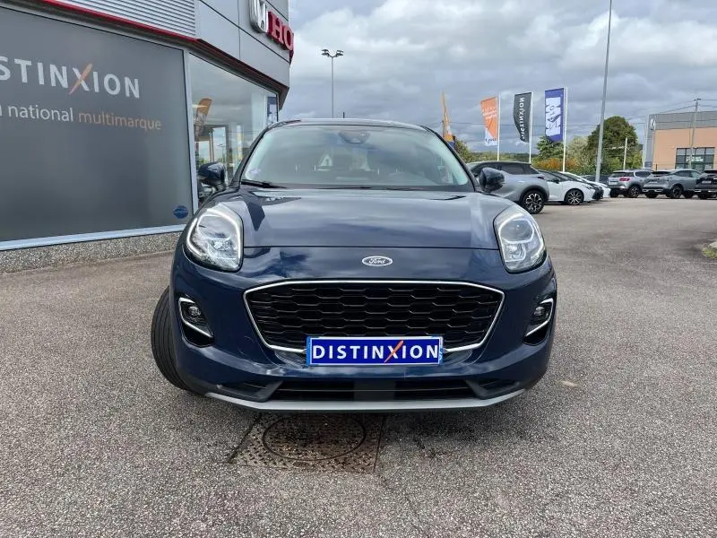Vue avant d'un Ford Puma bleu Abysse avec calandre noire et plaque Distinxion sur un parking extérieur