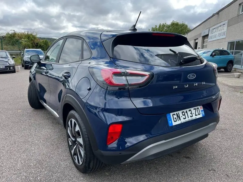 Vue 3/4 arrière droite d'un Ford Puma bleu Abysse avec vitres arrière surteintées et jantes alliage 17 pouces.