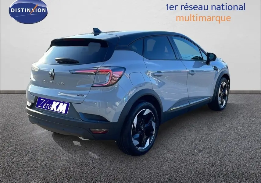 Renault Captur E-Tech hybride gris Rafale métal, vue 3/4 arrière côté droit avec toit noir et jantes bicolores.