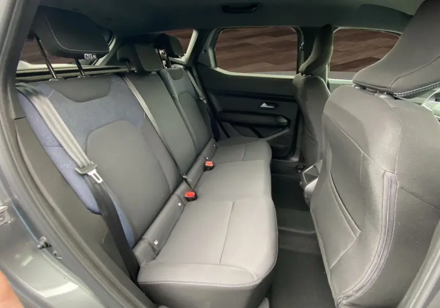 Vue intérieure côté droit des sièges arrière gris foncé du Dacia Duster Full Hybrid 140 Journey 2025 avec Pack Cold et City.