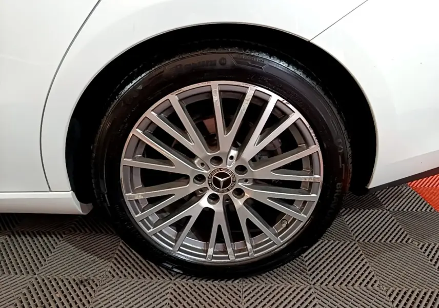 Gros plan sur la roue arrière droite d’une Mercedes CLA 200 d Business Line blanche, jante alliage multi-branches.