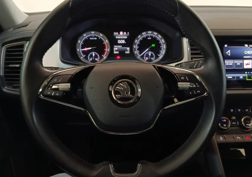 Vue rapprochée du volant noir en cuir du Skoda Kodiaq 2022 avec tableau de bord digital et commandes intégrées.