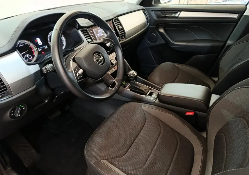 Intérieur avant droit du Skoda Kodiaq blanc 2022, avec tableau de bord digital et volant cuir multifonctions.