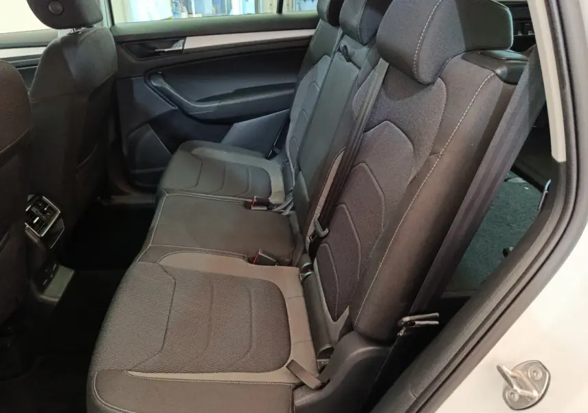 Vue côté droit de la banquette arrière noire du Skoda Kodiaq blanc 2022 avec ceinture et appuie-têtes visibles.