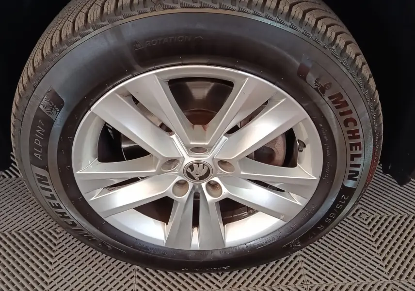 Gros plan sur la roue avant droite d’un Skoda Kodiaq blanc avec jante alliage et pneu Michelin Alpin 7.