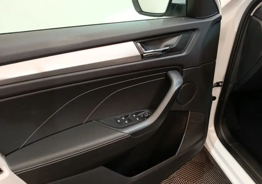 Vue intérieure côté gauche de la porte avant blanche du Skoda Kodiaq 2022 avec garniture noire et surpiqûres blanches.