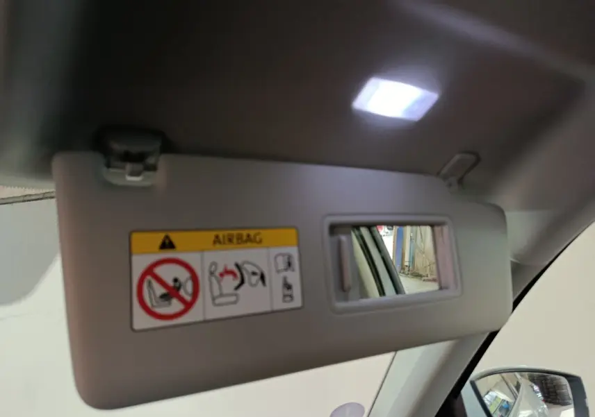 Détail intérieur du pare-soleil côté conducteur avec miroir éclairé dans un Skoda Kodiaq blanc 2022.