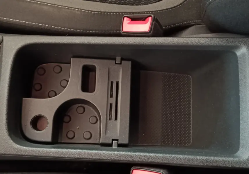 Gros plan sur le rangement central noir avec porte-cartes et ceintures de sécurité rouges dans un Skoda Kodiaq blanc.