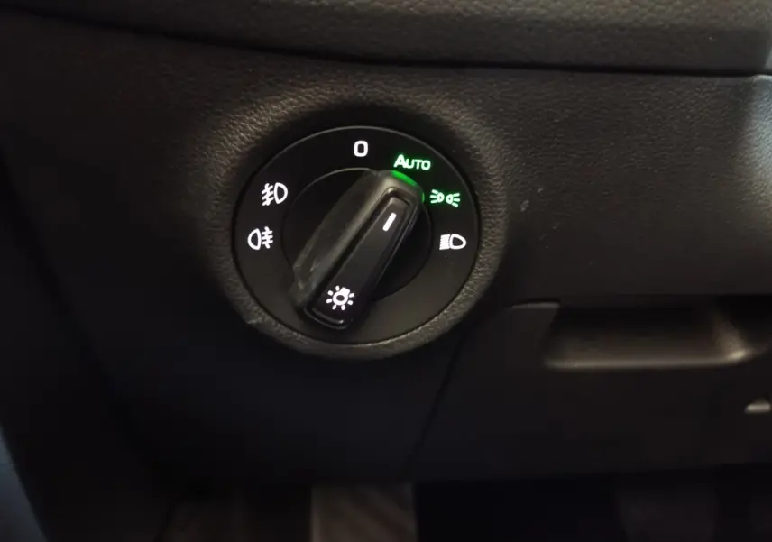 Commande rotative des phares en mode automatique sur tableau de bord noir du Skoda Kodiaq blanc 2022.