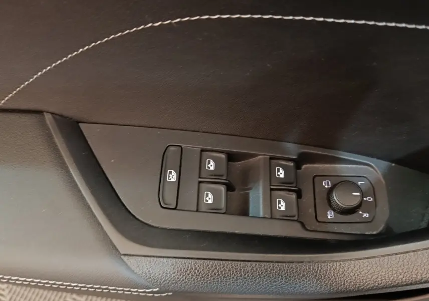 Commande des vitres électriques et réglage des rétroviseurs sur la porte côté conducteur d’un Skoda Kodiaq blanc.