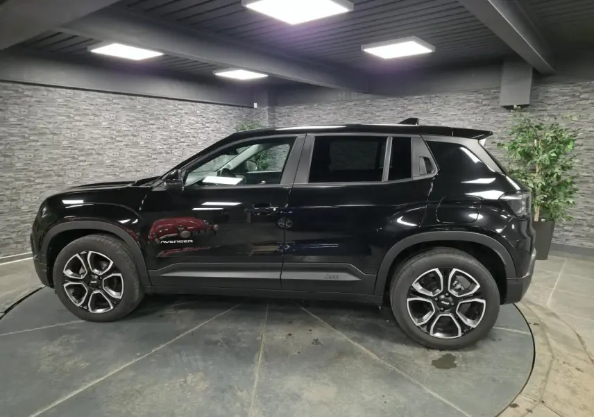 Vue de profil côté gauche du Jeep Avenger noir 2025 avec jantes alliage et vitres arrière surteintées.
