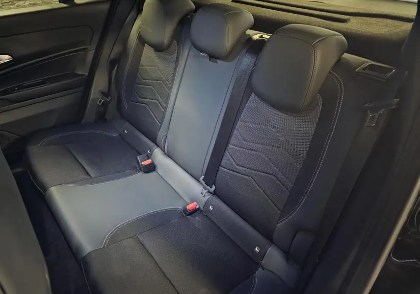 Vue intérieure de la banquette arrière noire du Jeep Avenger 2025 avec appuie-têtes et ceintures visibles.