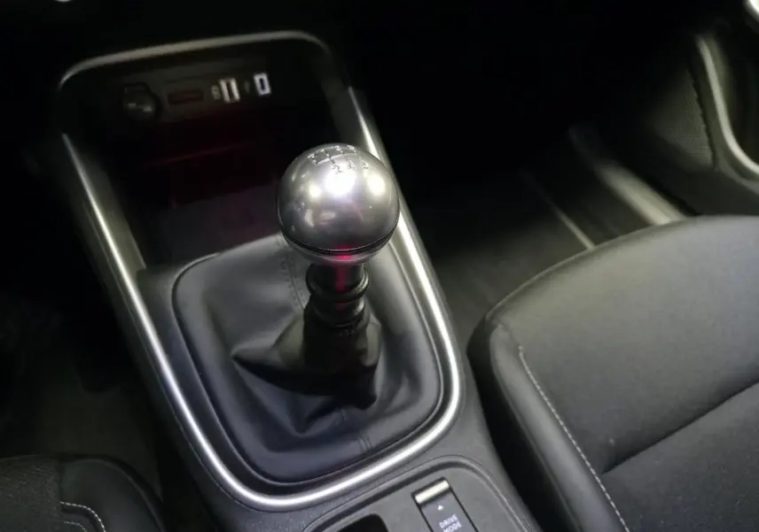 Gros plan sur le levier de vitesses manuel en métal et la console centrale noire du Jeep Avenger 2025.