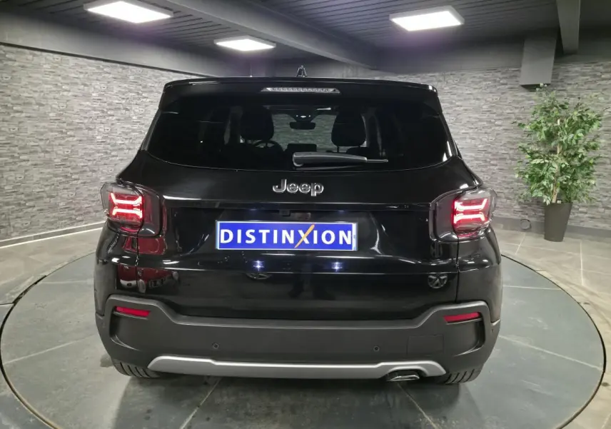 Vue arrière d'un Jeep Avenger noir 2025 avec feux LED allumés et plaque d'immatriculation Distinxion.
