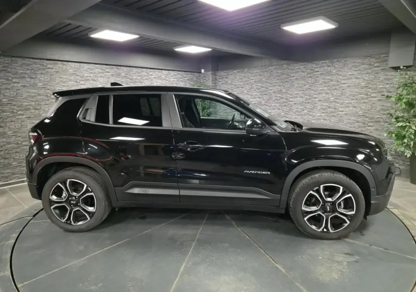 Jeep Avenger noir vu de profil côté gauche, avec jantes alliage distinctives et finition noire brillante.