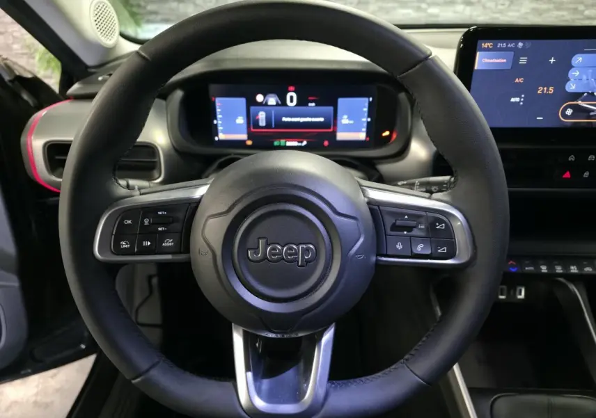 Vue frontale du volant noir Jeep Avenger 2025 avec commandes intégrées et tableau de bord numérique lumineux.